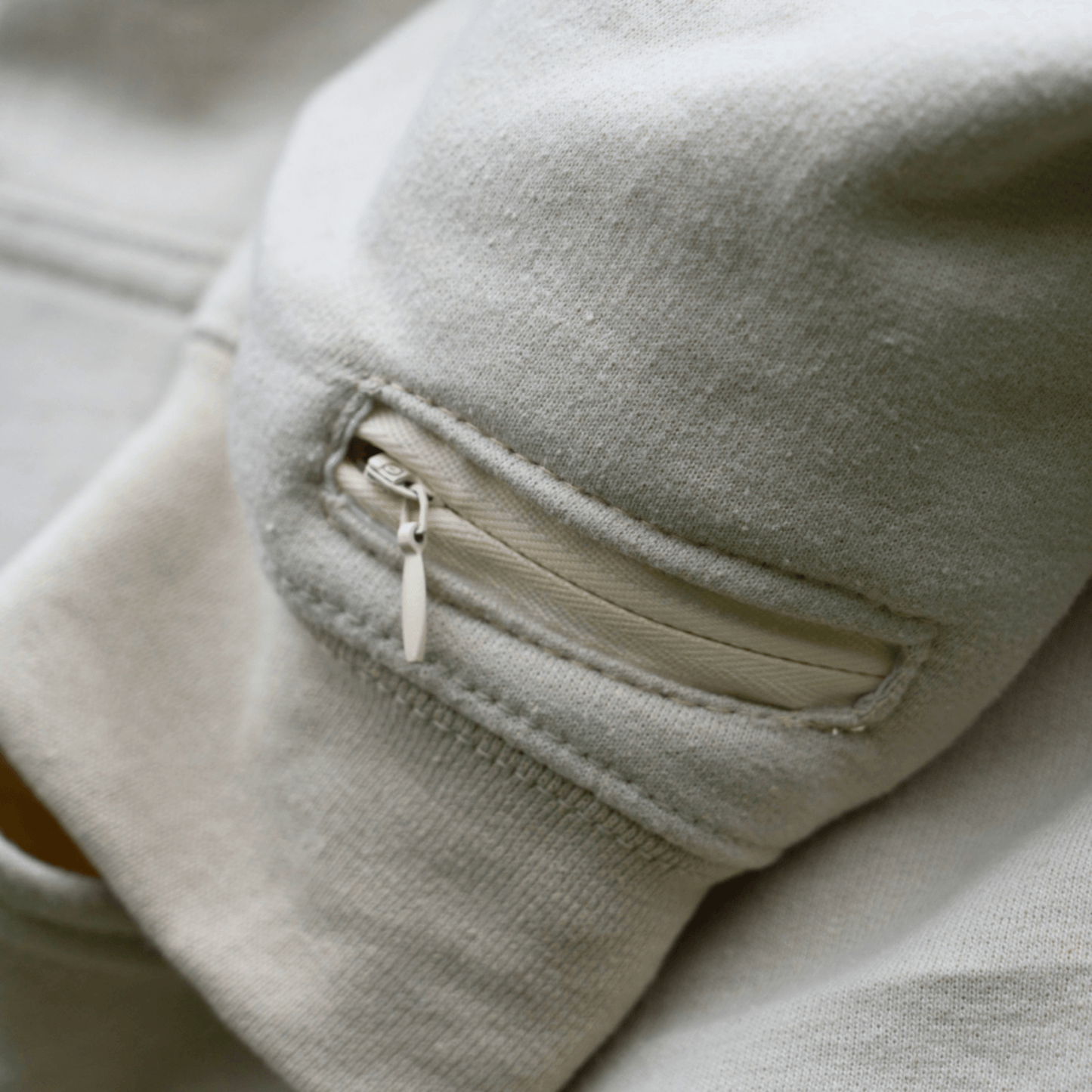 Close-up of a soft hoodie sleeve with a zipper pocket, perfect for storing essential oil blends for on-the-go aromatherapy